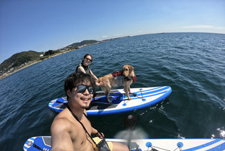 Hironobu paddleboarding with girlfriend and dog.